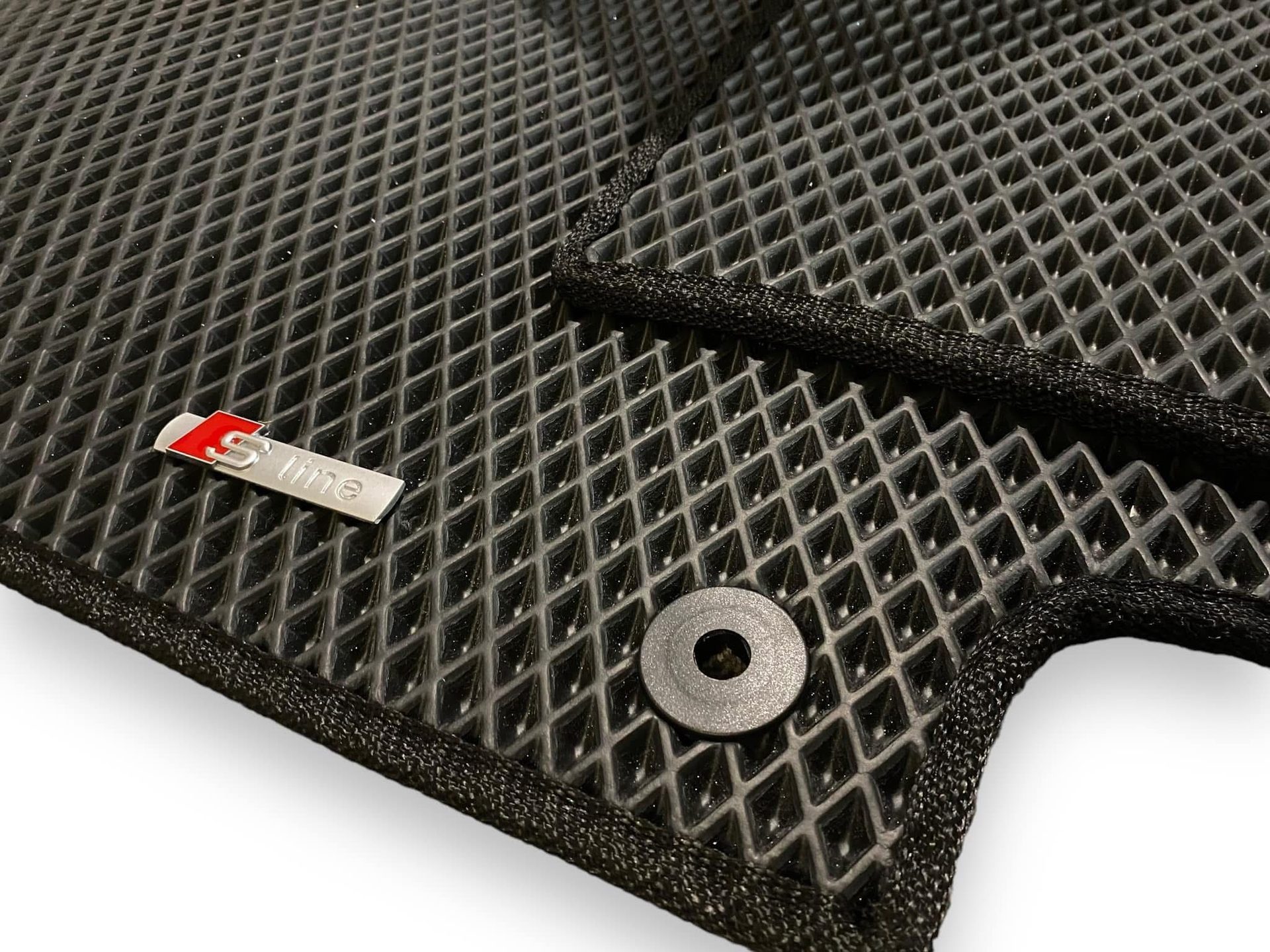 Close-up of a custom Audi S-line EVA car mat with diamond texture